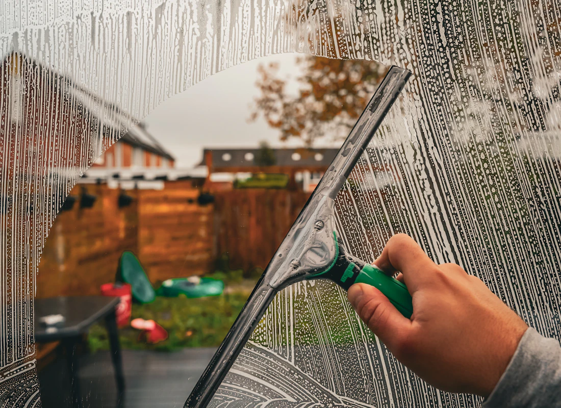 Window cleaner using a squeegee on a house window